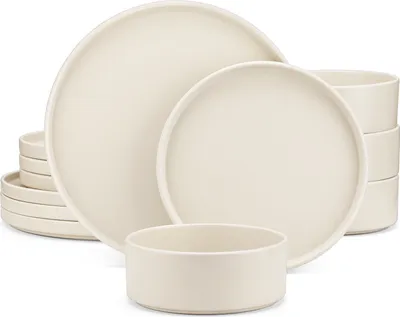 A set of cream-colored ceramic dishes, including plates and bowls, are arranged on a white background.