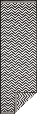 A black and white chevron patterned rug, with a corner folded back.