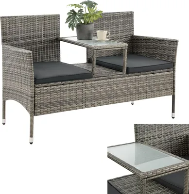 A grey rattan garden bench with a built-in table, a plant, and a cup on it, shown against a white background.