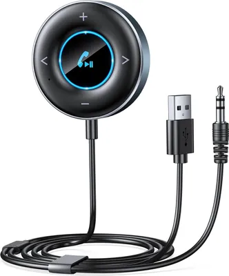 A close-up studio shot of a black circular Bluetooth adapter with a USB cable and a 3.5mm audio jack cable.