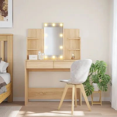 A well-lit bedroom scene featuring a wooden vanity table with a lighted mirror and a chair.