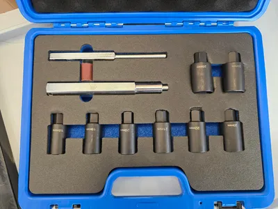 A tool kit for removing wheel lug nuts is neatly arranged in a blue case.