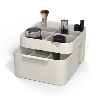 A makeup organizer with multiple compartments and a drawer, displayed on a white background.