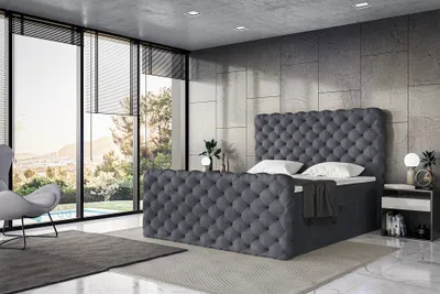 A modern bedroom with a large window overlooking a scenic view, featuring a tufted boxspring bed.