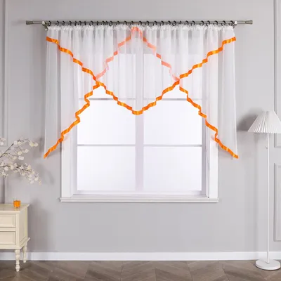 A sheer white curtain with orange trim is hung on a window.