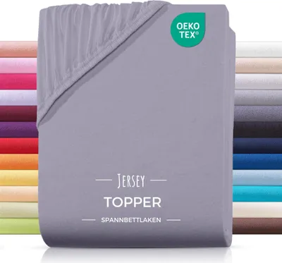 A stack of grey jersey fitted sheets with a side view showing a variety of other colored sheets.
