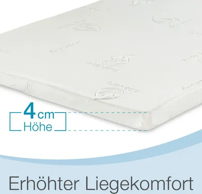 A close-up of a white mattress topper with embossed leaf patterns, showing a measurement indicator for its height.