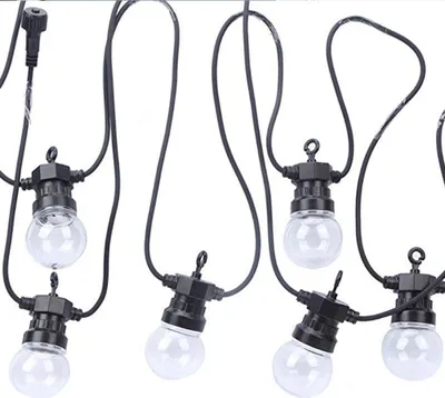 A string of clear globe-shaped LED bulbs with black wiring and sockets, suspended against a white background.