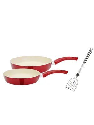 Two red frying pans and a spatula on a white background.