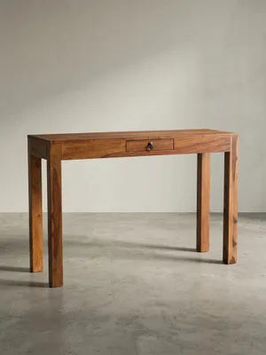 Platzsparender Homeoffice-Schreibtisch aus dunklem Sheesham-Holz in der 3/4-Ansicht, die die Tiefe und die massive Bauweise zeigt._#sku_BARKWL7.239#