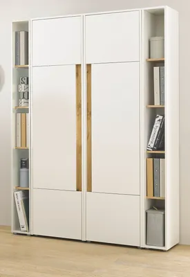 A white wardrobe with wood accents and shelves filled with books and decorative items.