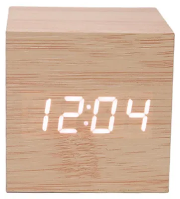 A close-up, front-facing view of a wooden cube-shaped digital clock displaying the time.