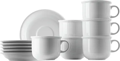 A collection of white ceramic cups and saucers are neatly stacked and arranged against a white background.