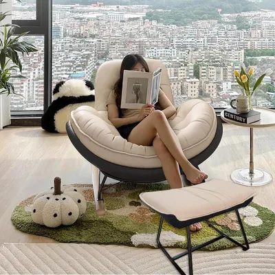 A woman is reading a book while sitting in a comfortable chair in a modern apartment with a city view.