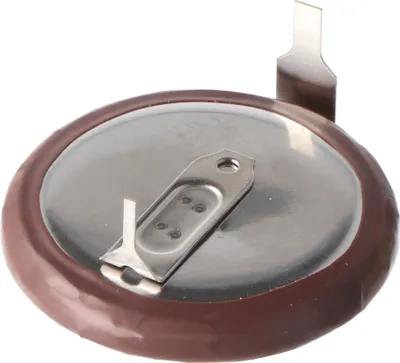 A close-up view of the top of a coin cell battery with two metal tabs attached.