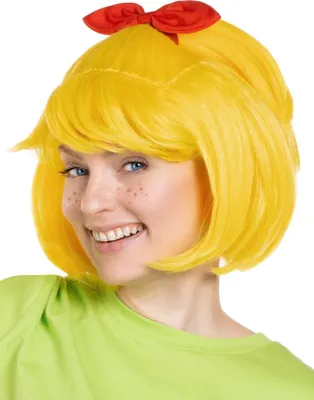 A woman wearing a bright green shirt and a yellow wig with a red bow on top, smiling at the camera.