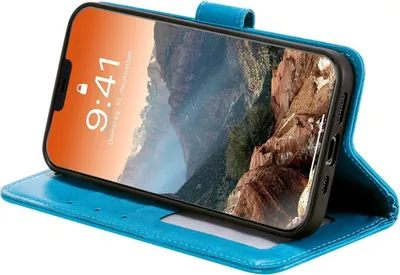 A blue flip case cover for an iPhone 12 Pro Max is shown open, displaying the phone's screen with a mountain landscape wallpaper.