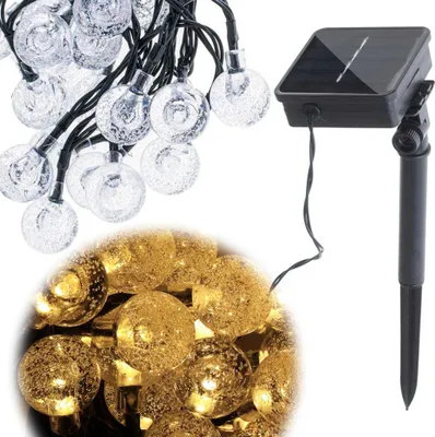 A string of solar-powered garden lights with clear, bubble-like bulbs and a separate solar panel unit.