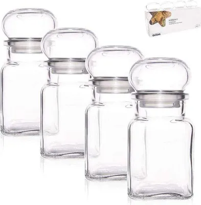 Four clear glass spice jars with silver lids are arranged in a row on a white background. A small box with product information is in the upper right corner.