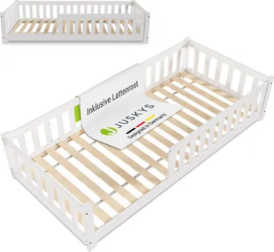 A white wooden bed frame with a slatted base, shown from a diagonal angle. A label is draped over the side rail.