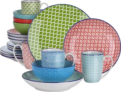 A collection of ceramic dinnerware, including plates, bowls, and mugs, arranged in a stack and group.