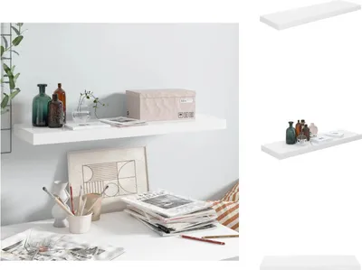 A white floating shelf mounted on a white wall, decorated with bottles, a box, and a plant. Below the shelf is a desk with art supplies and magazines.