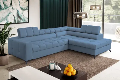 A modern living room with a blue sectional sofa, coffee table, and artwork.