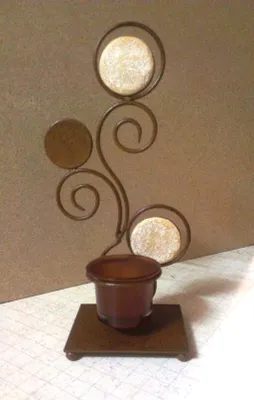 Ein kunstvoller Teelichthalter der aus einer Kombination aus Metall und Stein besteht.
