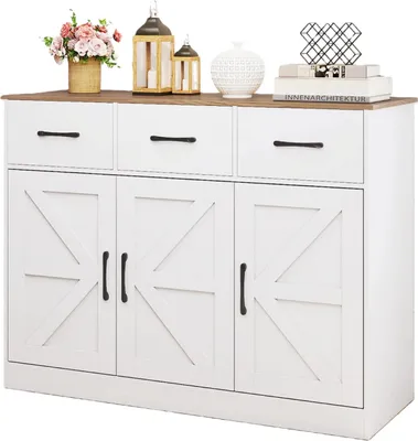 A white buffet cabinet with a brown top and black handles, decorated with various items on top.