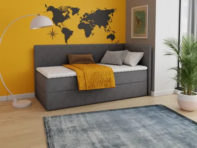 A bedroom scene with a daybed against a yellow wall decorated with a world map.