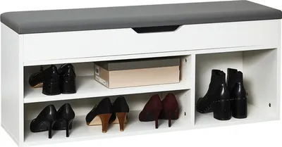 A white shoe cabinet with a gray upholstered seat and multiple shelves holding shoes and a shoebox.