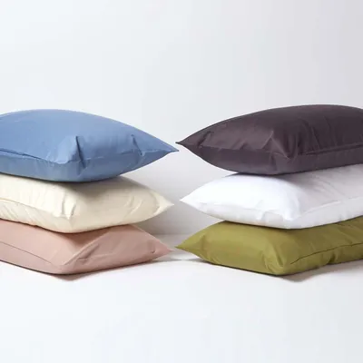 A stack of six pillows in different colors against a white background.