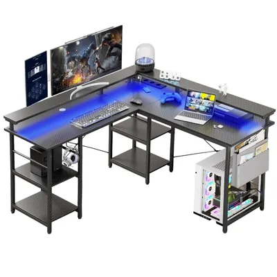 An L-shaped gaming desk with LED lighting, monitors, a laptop, and a computer tower.