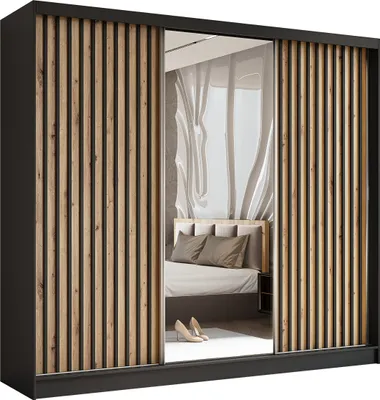 A wardrobe with sliding doors, one of which is mirrored, reflecting a bedroom interior.