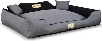 A dog bed with raised sides and two small pillows.