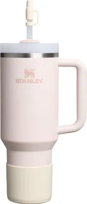 A pink Stanley Quencher tumbler with a straw and a cream-colored boot.