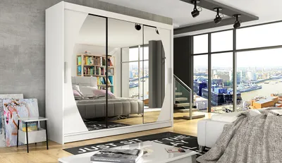 A modern bedroom with a large wardrobe with mirrored doors, a bed, and a large window overlooking a city.