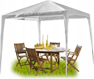 A white gazebo with a wooden table and chairs set up on green grass.
