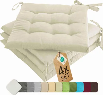 A stack of cream-colored seat cushions with ties, a product tag, and a color swatch strip.