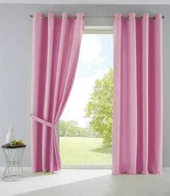 Pink curtains are tied back with a tie-back, revealing a green landscape and sky through a window. A small side table with decorative items is to the left.