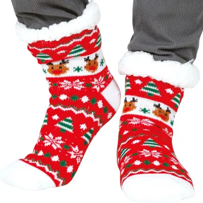 Rote Weihnachtssocken mit Rentier- und Tannenbaum-Motiv an den Füßen getragen.