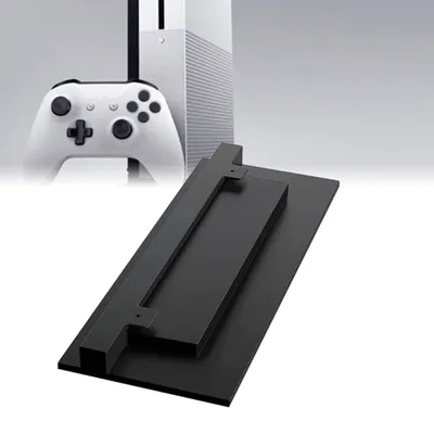 A white Xbox One S console and controller are shown in the background, with a black vertical stand in the foreground.