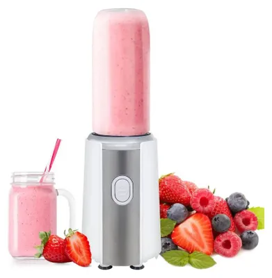 A portable blender with a smoothie in the bottle, a glass of smoothie, and a pile of fresh berries.