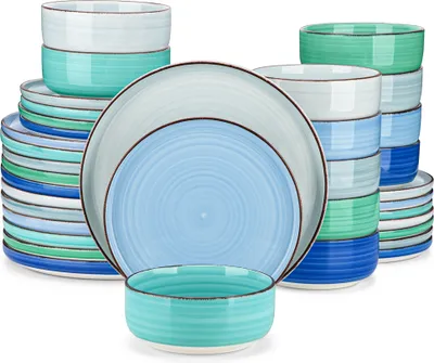 A collection of stacked ceramic plates and bowls in various shades of blue and green.