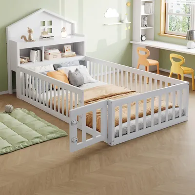 A child's bed with protective railings and a headboard shelf, set in a room with a desk and chairs.