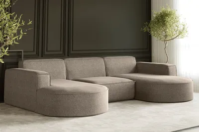 A modern U-shaped sectional sofa in a warm beige fabric, set against a dark gray paneled wall and a light gray carpet.