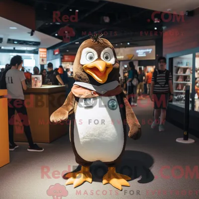 Produktbild von Maskottchencharakter REDBROKOLY eines braunen Pinguins mit T-Shirt und Uhren
