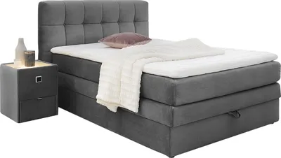 A bed with a headboard, mattress, and a nightstand next to it.