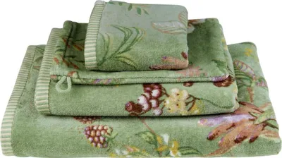A stack of three green towels with a floral and berry pattern.