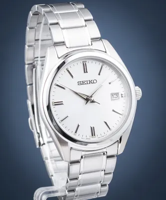 A close-up studio shot of a silver Seiko watch with a white face.